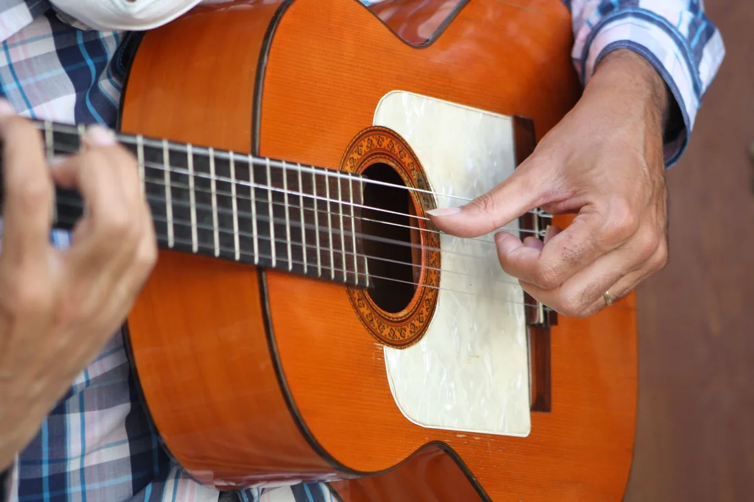 Close detail of a flamenco guitarist's hands on the strings
